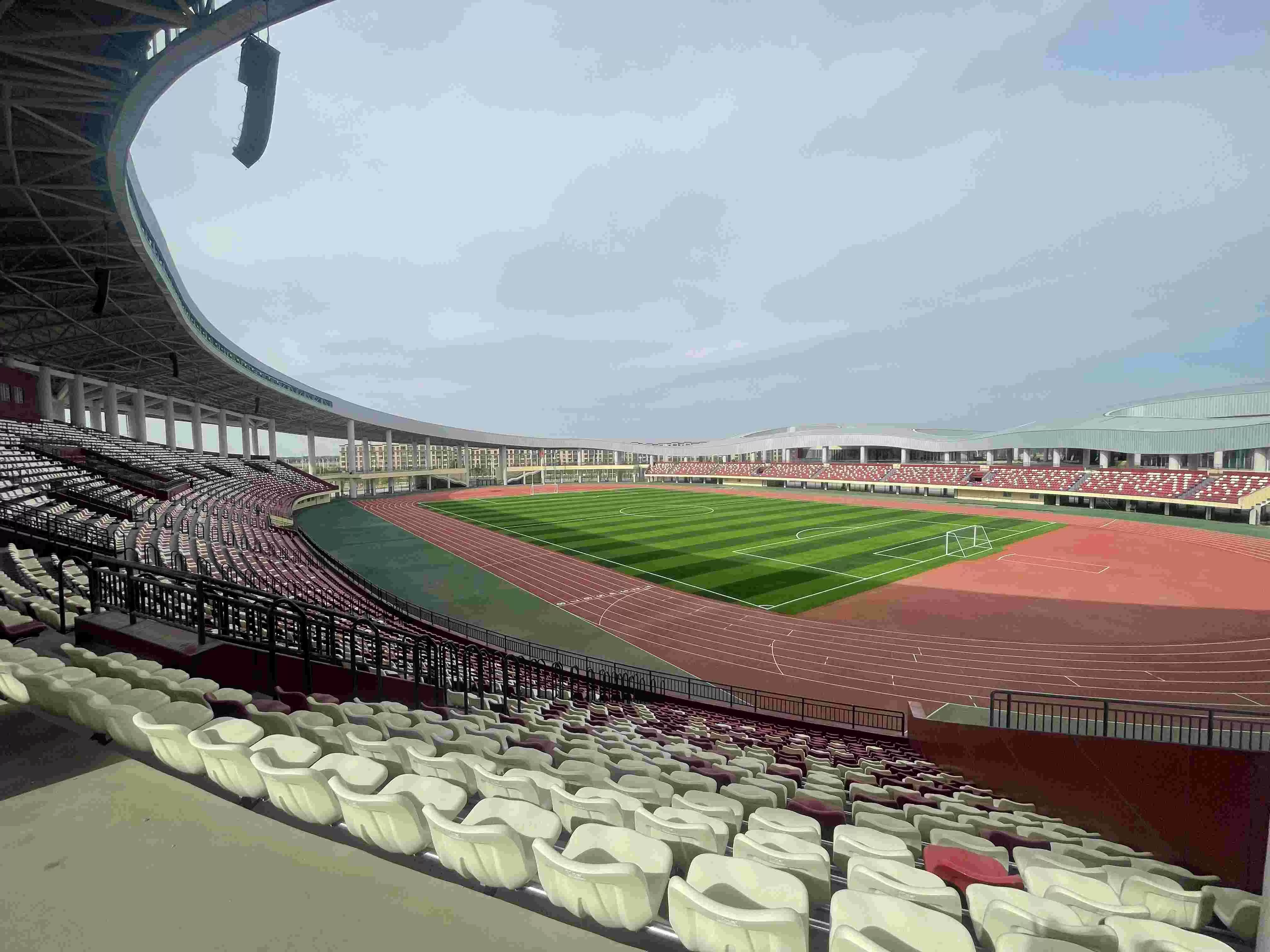 Sports stadium interior with 30,000+ hollow blow-molded integral fixed seats, athletic track, and grandstands – project by professional stadium seating supplier