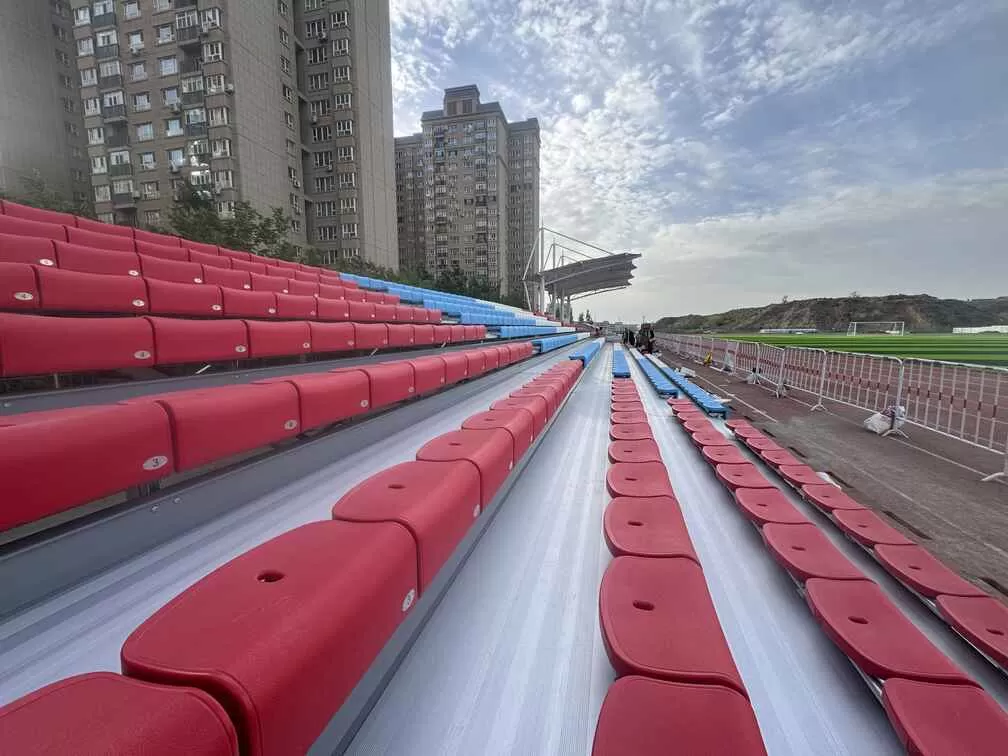 Outdoor metal bleachers with colorful seats at Xinjiang school football field, galvanized steel grandstand