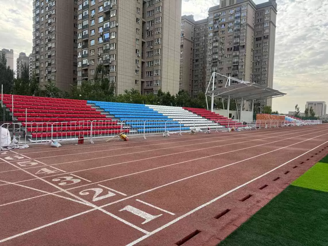 Outdoor metal bleachers with colorful seats at Xinjiang school football field, galvanized steel grandstand